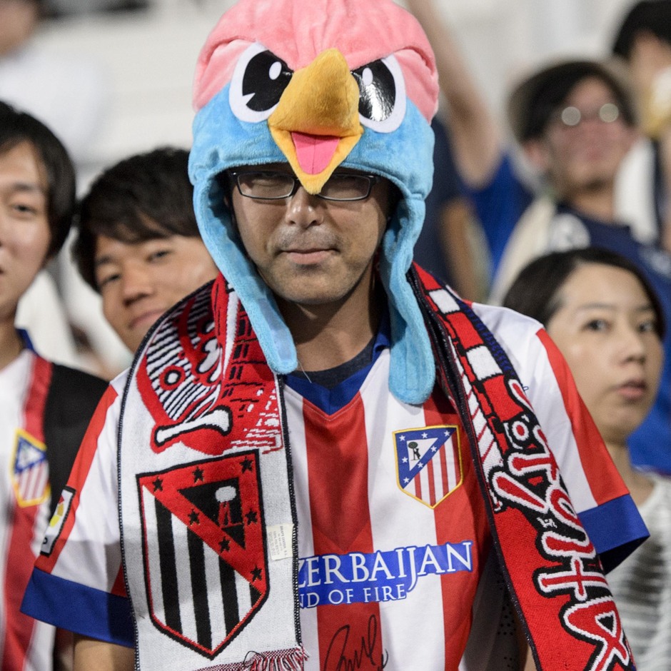 Un aficionado ataviado con un gorro de pollo anima al Atlético en Saga