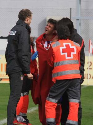 Héctor Hernández, del Atlético B, es atendido por las asistencias antes de ser retirado en camilla por una fractura de la clavícula izquierda