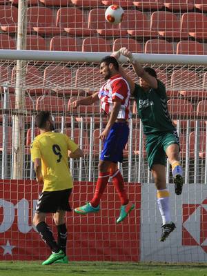 Kader, del Atlético B, intenta rematar un balón ante la oposición del portero de Las Palmas Atlético Alex