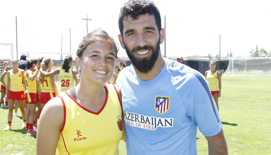 Arda Turan se hace una foto junto a una de las jugadoras de la selección española de hockey hierba