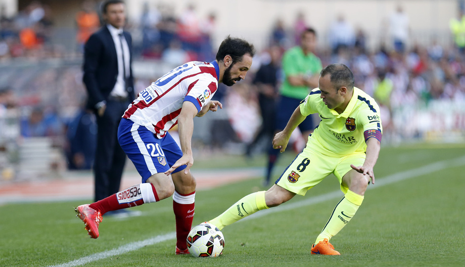 Temporada 14-15. Jornada 37. Atlético de Madrid - FC Barcelona. Juanfran busca el hueco para lanzar el pase ante la oposición de Iniesta.