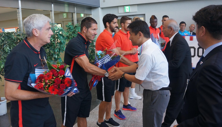 Clemente Villaverde y Diego Pablo Simeone reciben el saludo de la comitiva japonesa en el aeropuerto de Fukuoka