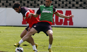 Raúl García y un canterano pujan por un balón