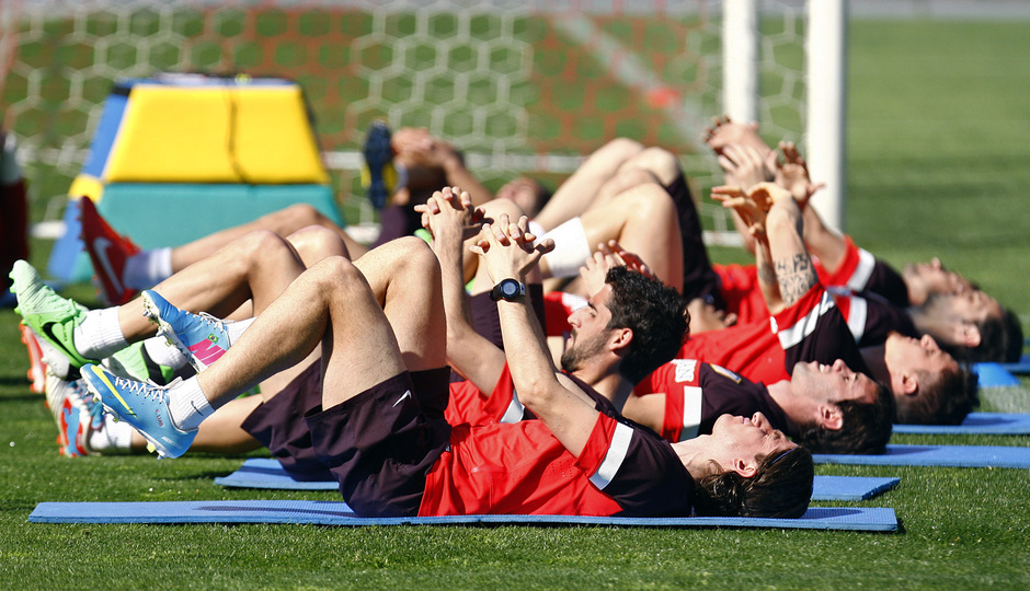 Temporada 12/13. Entrenamiento grupo de jugadores estirando señalando la grada durante el entrenamiento en el estadio Vicente Calderón
