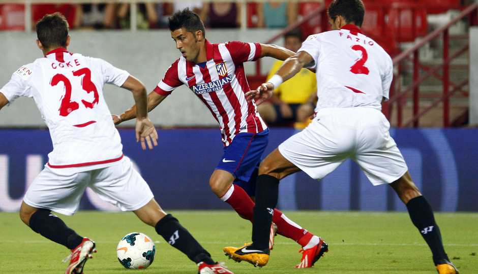 Temporada 13/14 Sevilla-Atlético de Madrid David Villa disputando un balón entre dos jugadores sevillitas 