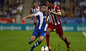 Koke conduciendo el balón ante la presión de un jugador del Espanyol