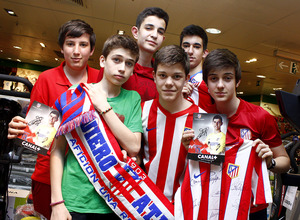 Un grupo de jóvenes posa con los colores del Atleti y la foto autografiada de uno de sus ídolos