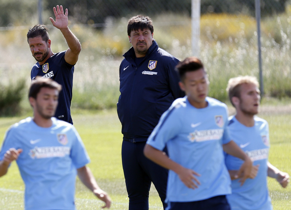 Simeone saluda, en presencia de Germán Burgos, mientras sus jugadores realizan trabajo físico