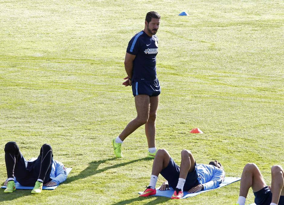 Simeone pasea mientras observa los ejercicios físicos de sus jugadores