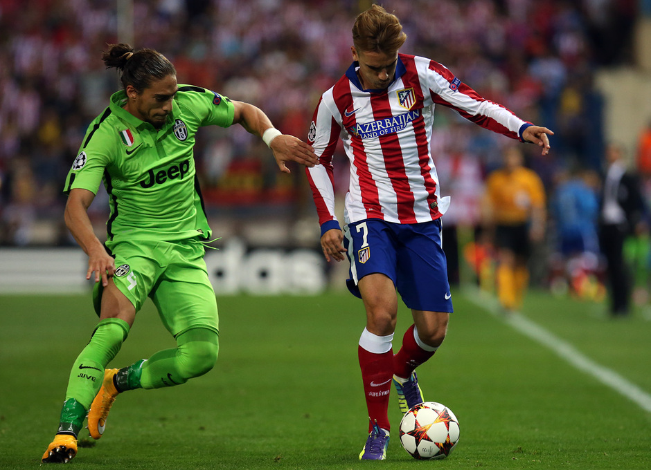 Temporada 14-15. Atlético-Juventus. Griezmann corre con el balón junto a Cáceres.