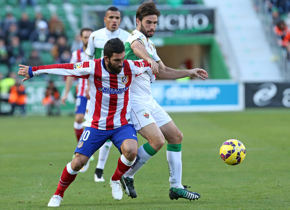 Temporada 14-15. Jornada 14. Elche - Atlético de Madrid. Arda protege el balón ante un rival.