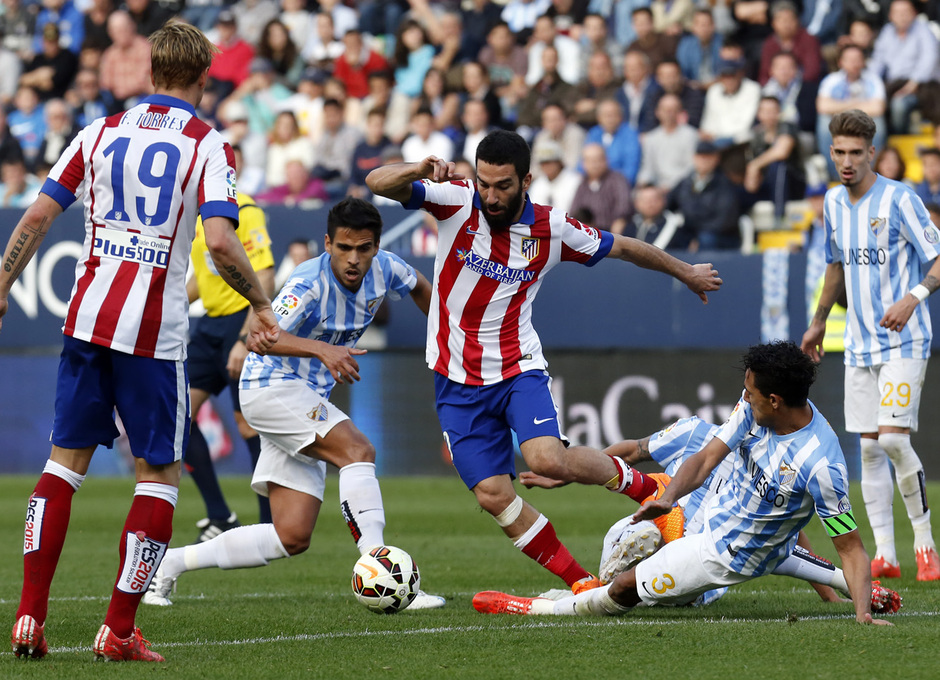 Temporada 14-15. Jornada 31. Málaga -Atlético de Madrid. Arda esquiva la entrada de varios rivales.