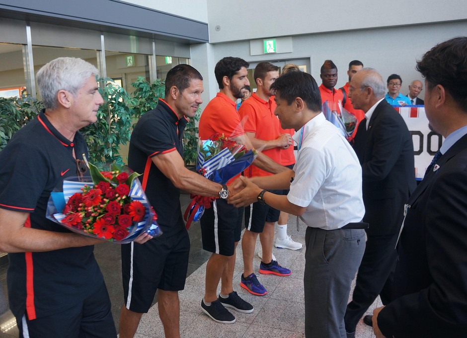 Clemente Villaverde y Diego Pablo Simeone reciben el saludo de la comitiva japonesa en el aeropuerto de Fukuoka