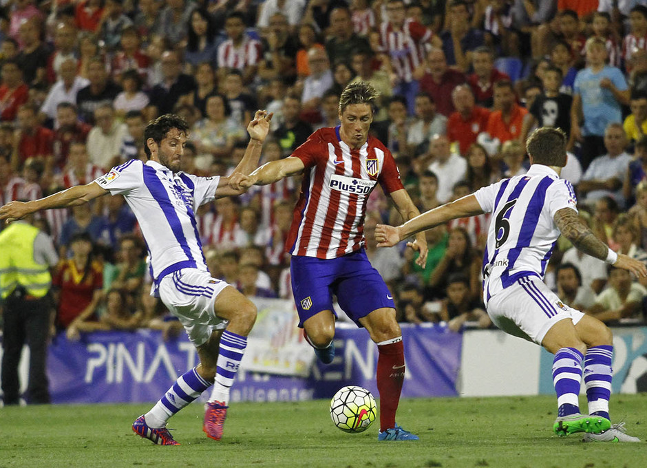 Partido amistoso Atlético de Madrid - Real Sociedad. Fernando Torres pasa entre dos futbolistas rivales