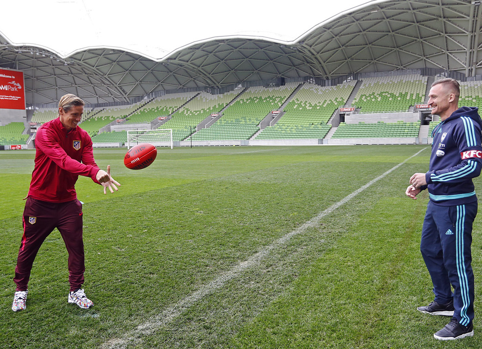 Torres da un pase con la mano a Berisha con el balón de fútbol australiano