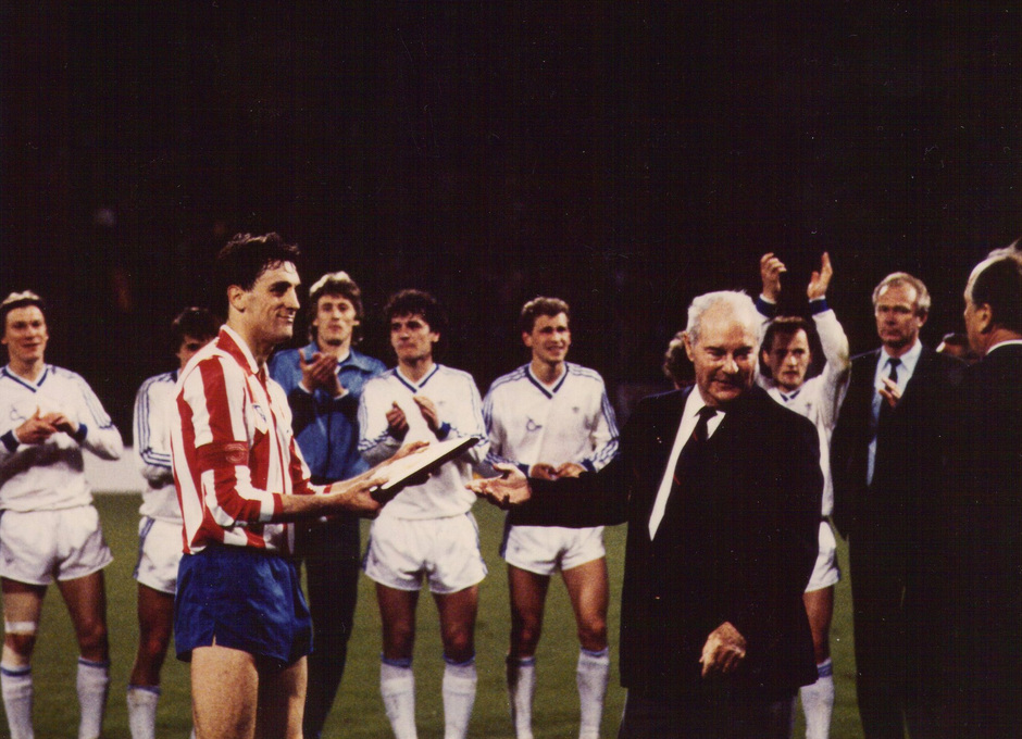 Miguel Ángel Ruiz, capitán rojiblanco, recibe la placa de subcampeón de la Recopa de 1986