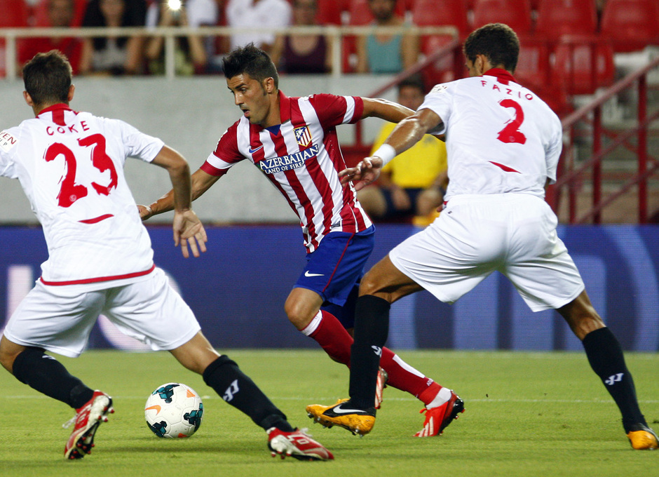 Temporada 13/14 Sevilla-Atlético de Madrid David Villa disputando un balón entre dos jugadores sevillitas 