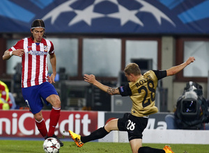 Filipe Luis controlando el balón ante la entrada de un jugador rival
