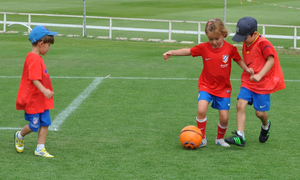 Tres niños pequeños entrenan en las escuelas de tecnificación de la Fundación Atlético de Madrid.