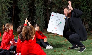 Simeone, entrenador de fútbol del Atlético de Madrid,  con unos niños. © Atlético de Madrid.