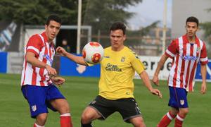 Vicente, jugador del Atlético B, da un pase en el partido contra Las Palmas Atlético ante la oposición del canario Roque