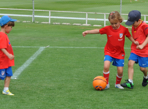 Tres niños pequeños entrenan en las escuelas de tecnificación de la Fundación Atlético de Madrid.