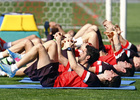 Temporada 12/13. Entrenamiento grupo de jugadores estirando señalando la grada durante el entrenamiento en el estadio Vicente Calderón