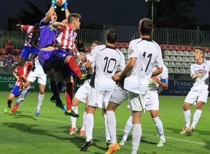 Aquino y Galass intentar llegar a cabecear el balón en un córner que atrapa el meta del Tudelano, Asín